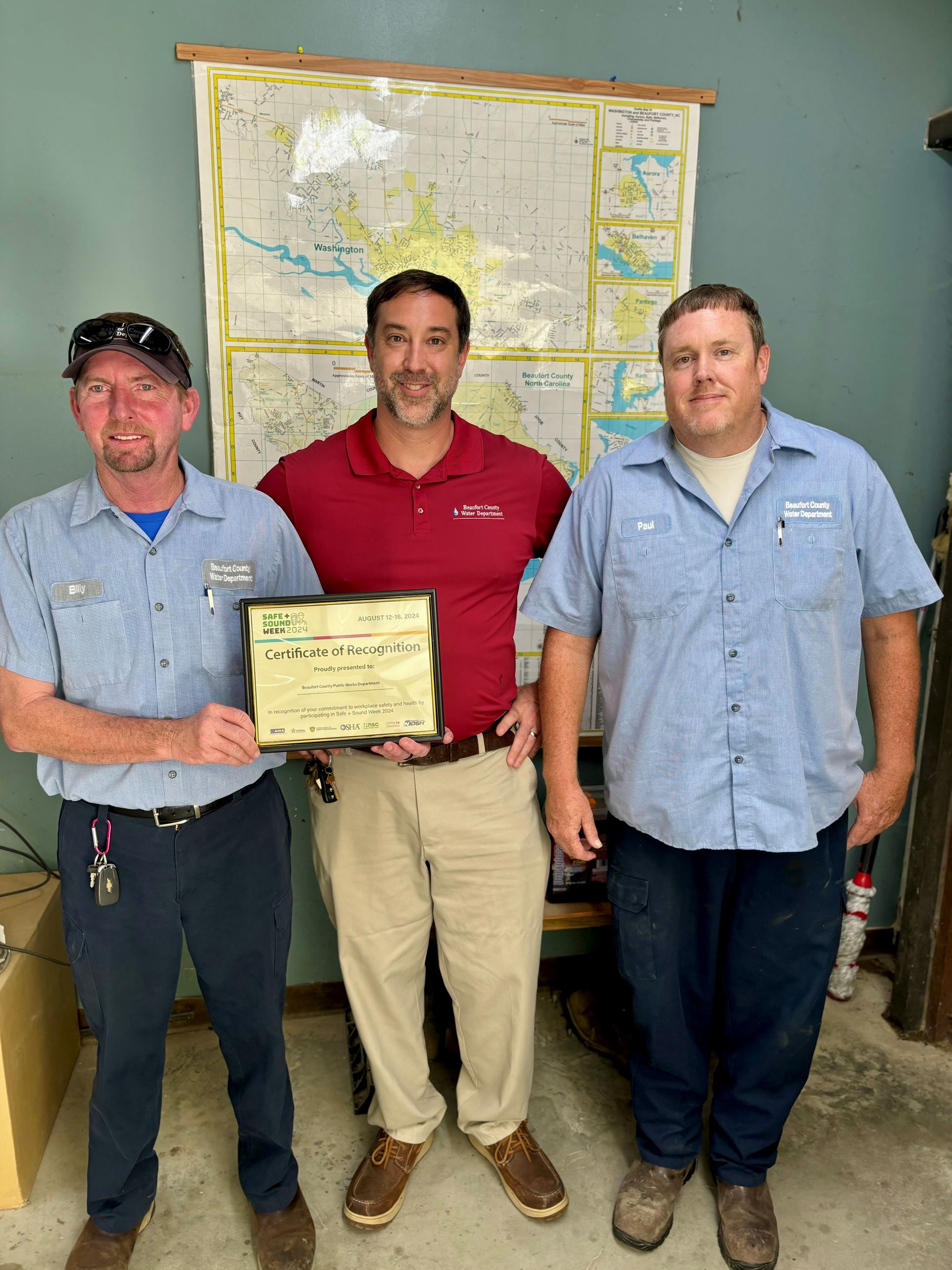 A group of employees holding a certificate