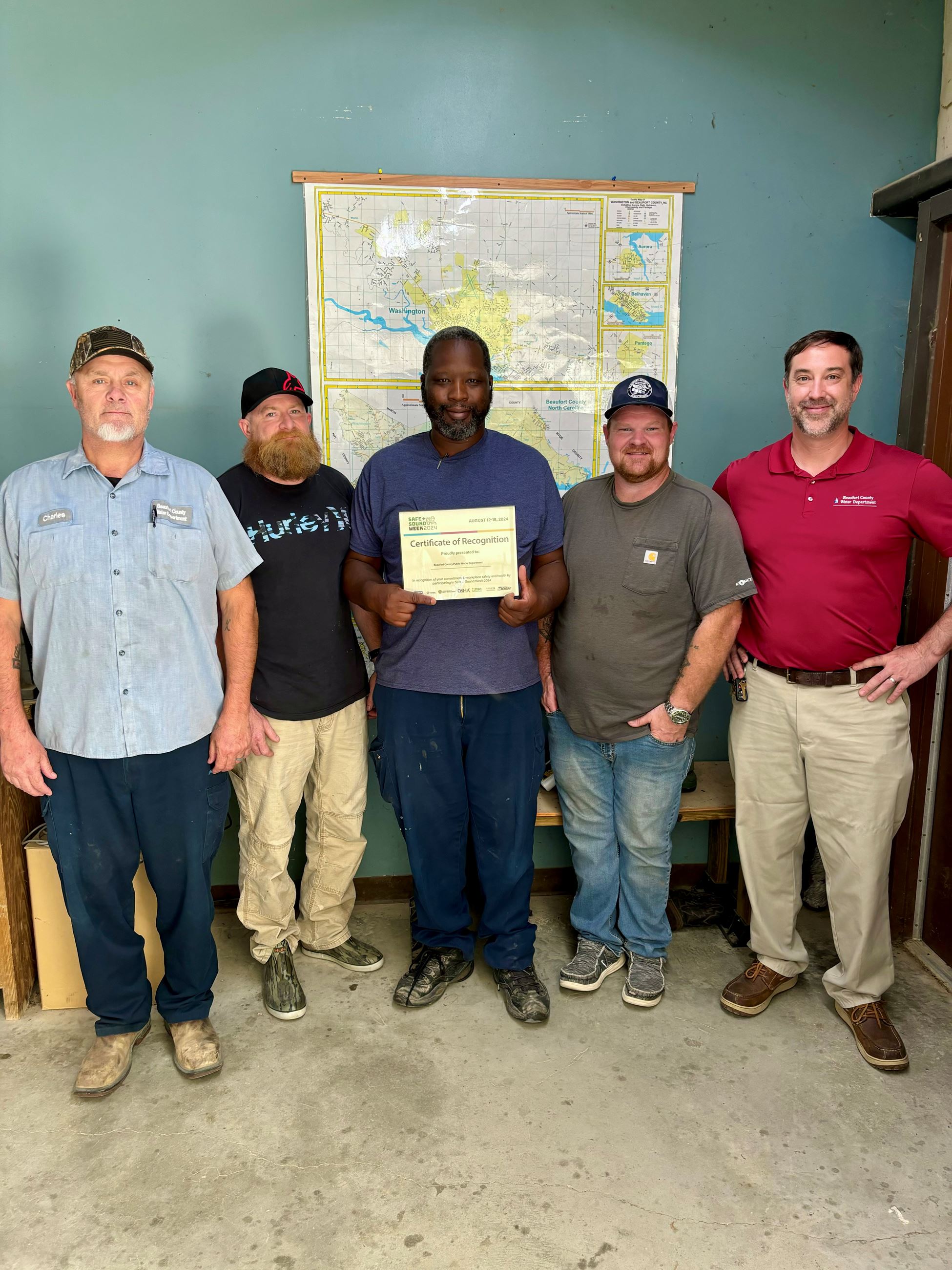 A group of employees holding a certificate