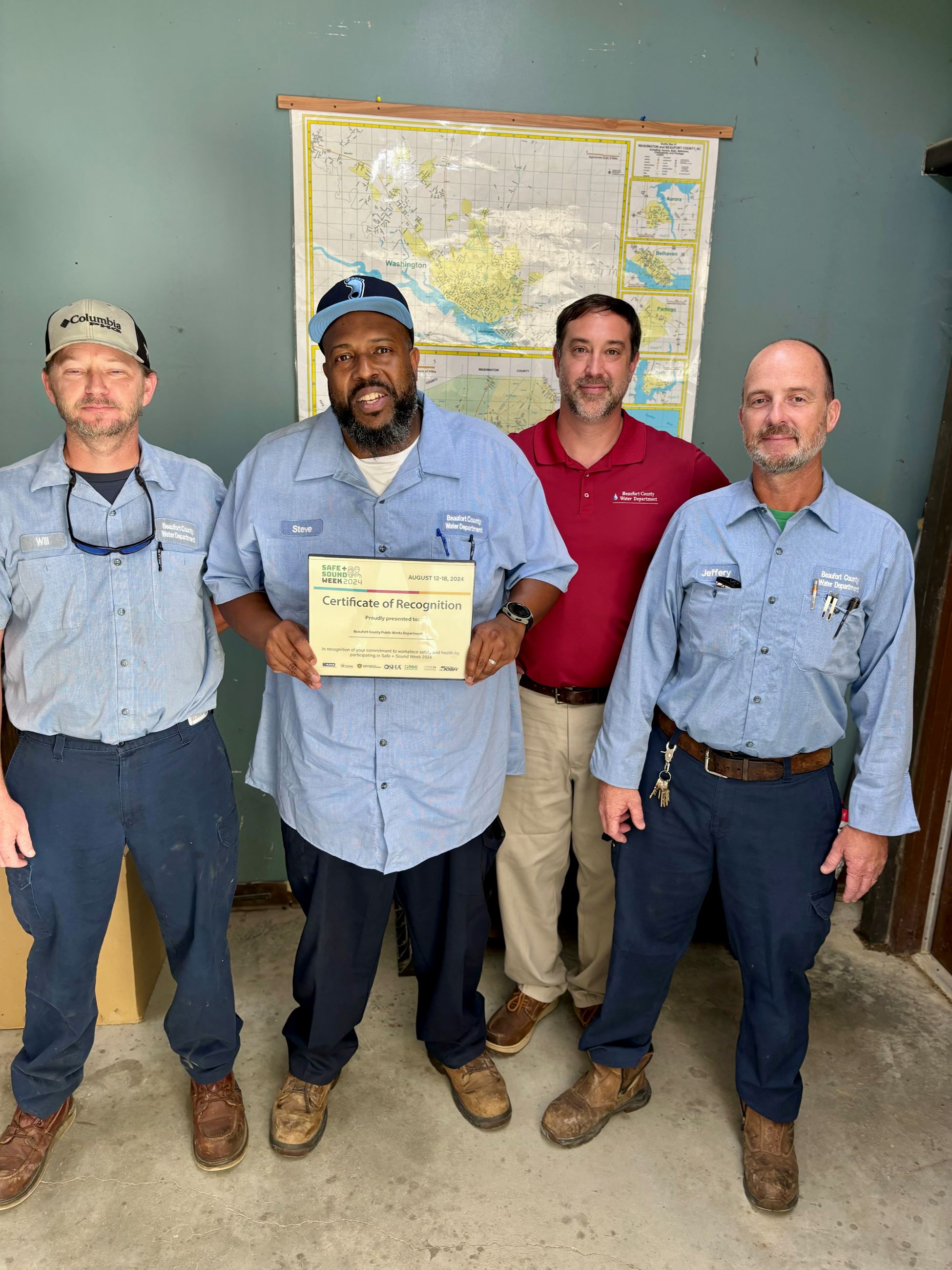 A group of workers holding a certificate