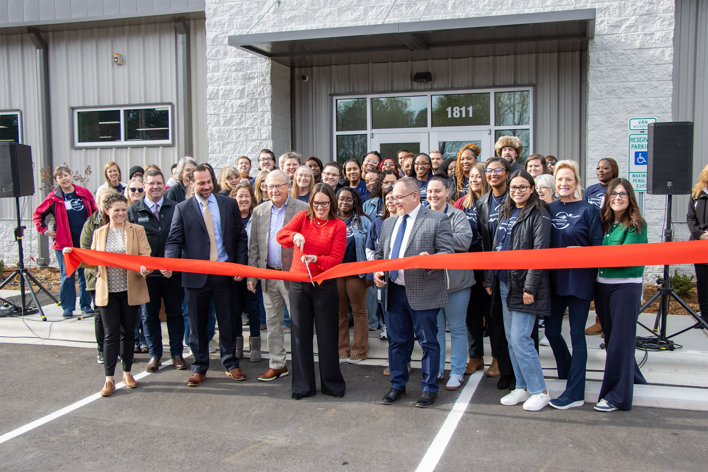With a crowd standing behind her, Pharmacy Director Kennedy Blount cuts the ribbon.