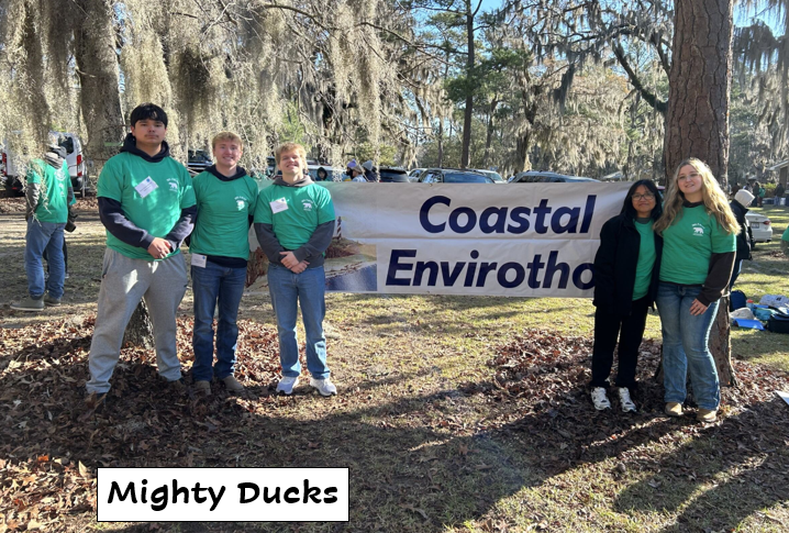 Five students standing in front of a Coastal Envirothon banner