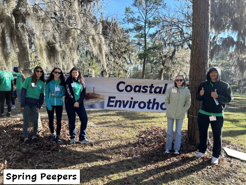 Five students standing in front of a Coastal Envirothon banner