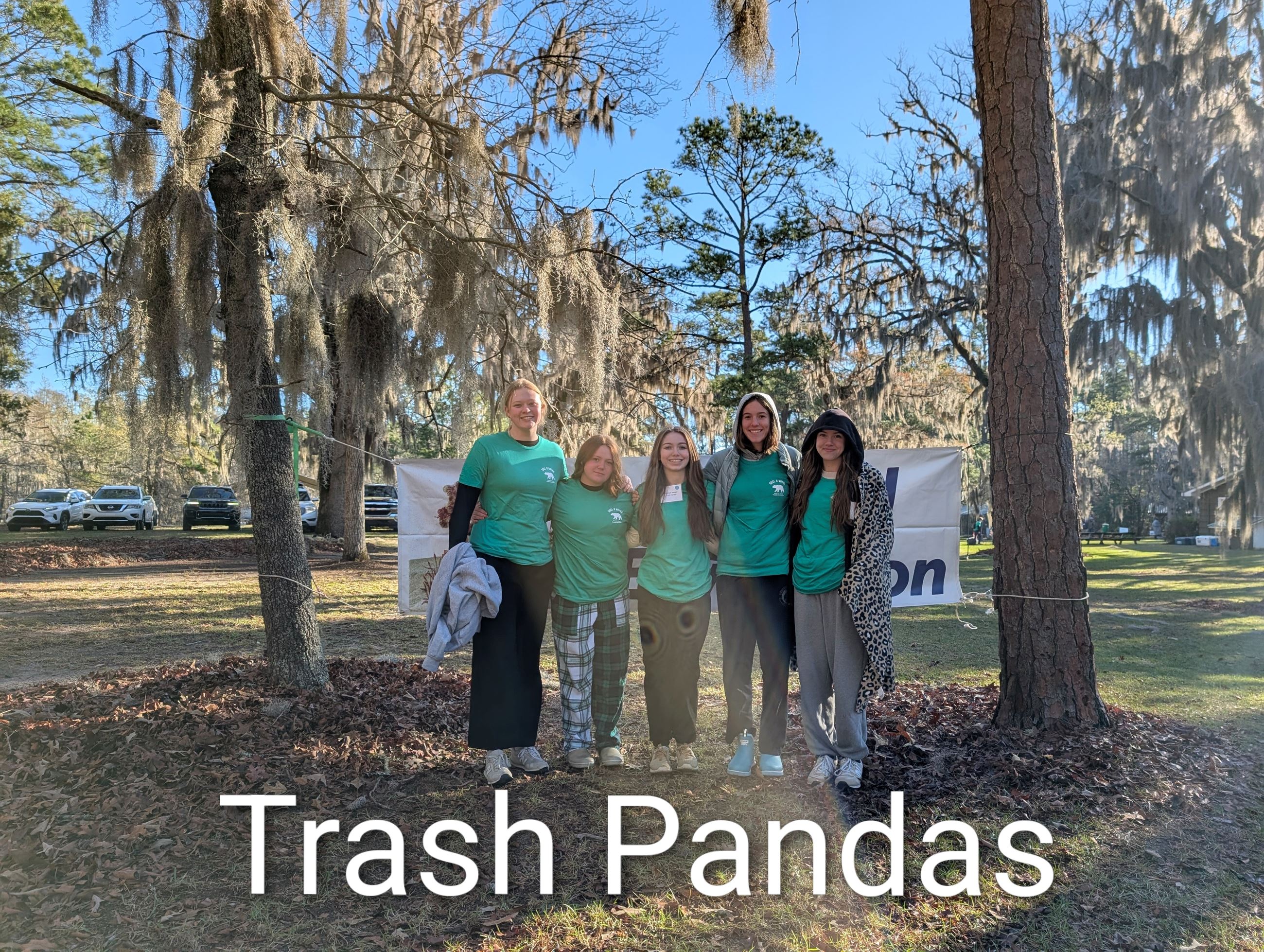 Five students standing in front of a Coastal Envirothon banner